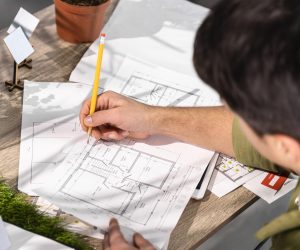 high-angle-man-working-eco-friendly-wind-power-project-with-papers-pencil